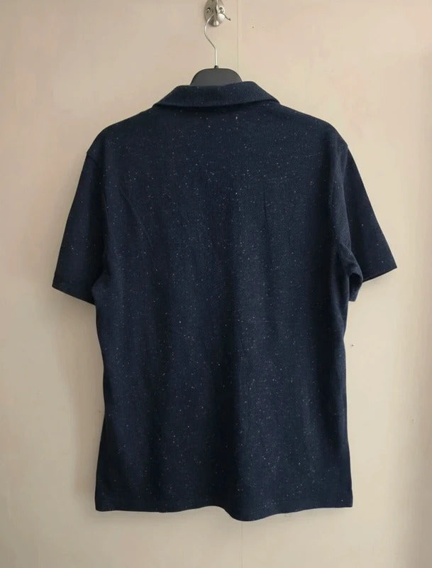 A dark navy blue short-sleeve polo shirt with a subtle speckled texture, hanging on a black hanger against a plain beige wall.