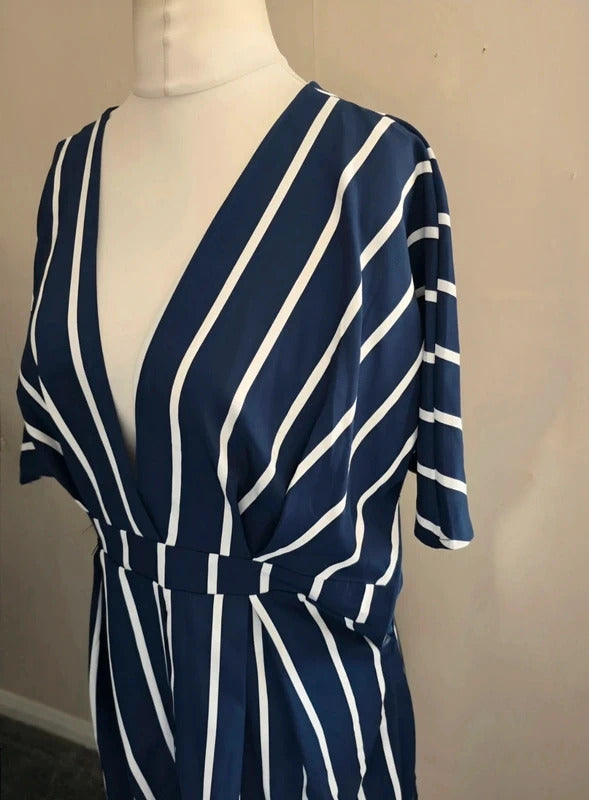A navy blue and white vertically striped wrap dress displayed on a white mannequin torso against a plain beige wall.