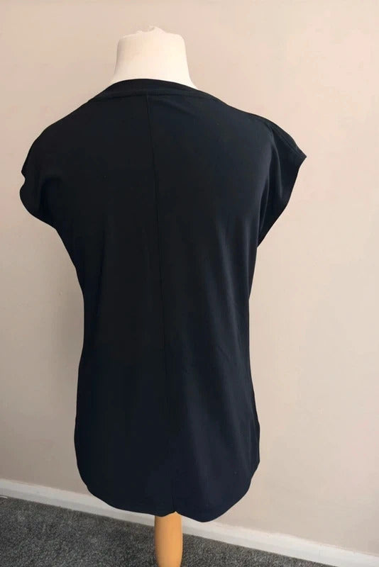 A black short-sleeve top displayed on a mannequin torso, photographed indoors against a plain light wall.