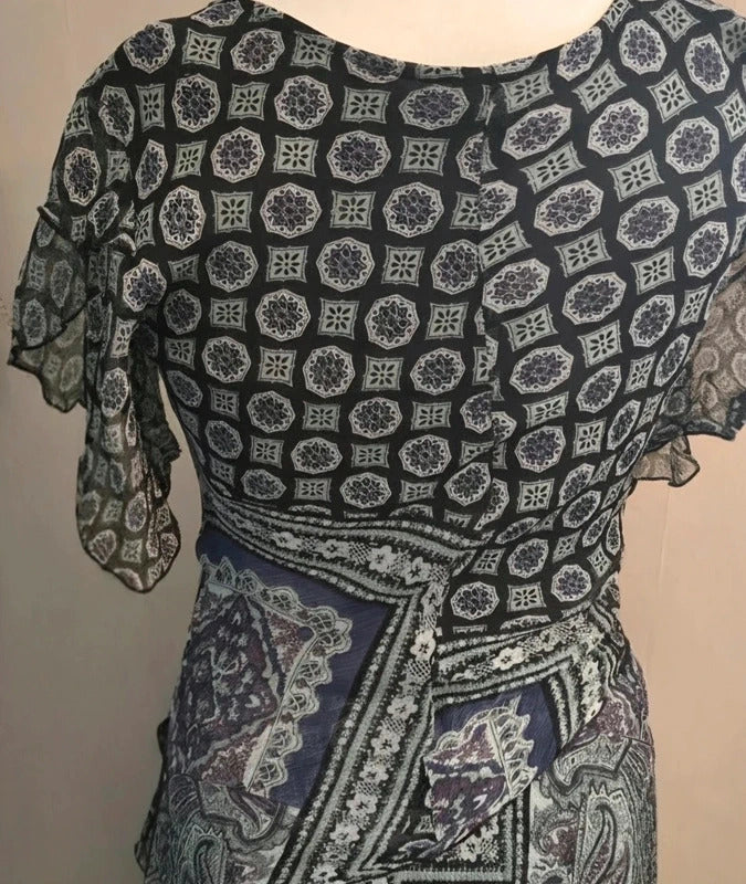 A black and gray patterned dress with sheer flutter sleeves and a matching patterned skirt, displayed on a mannequin torso against a plain beige background.
